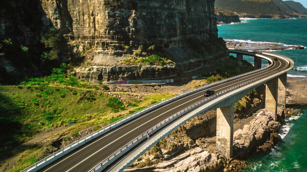 Autovía carreteras con puente de hormigón de canto variable bordeando la costa integrada